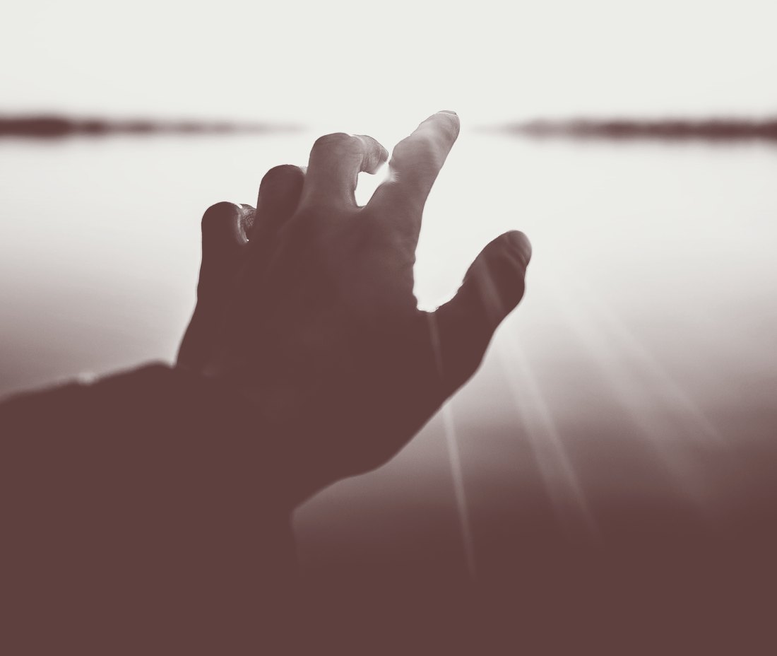 a hand reaching toward the light